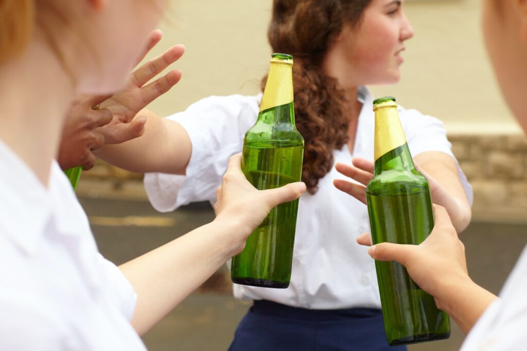 No. Young female student turning down alcohol in response to peer pressure.