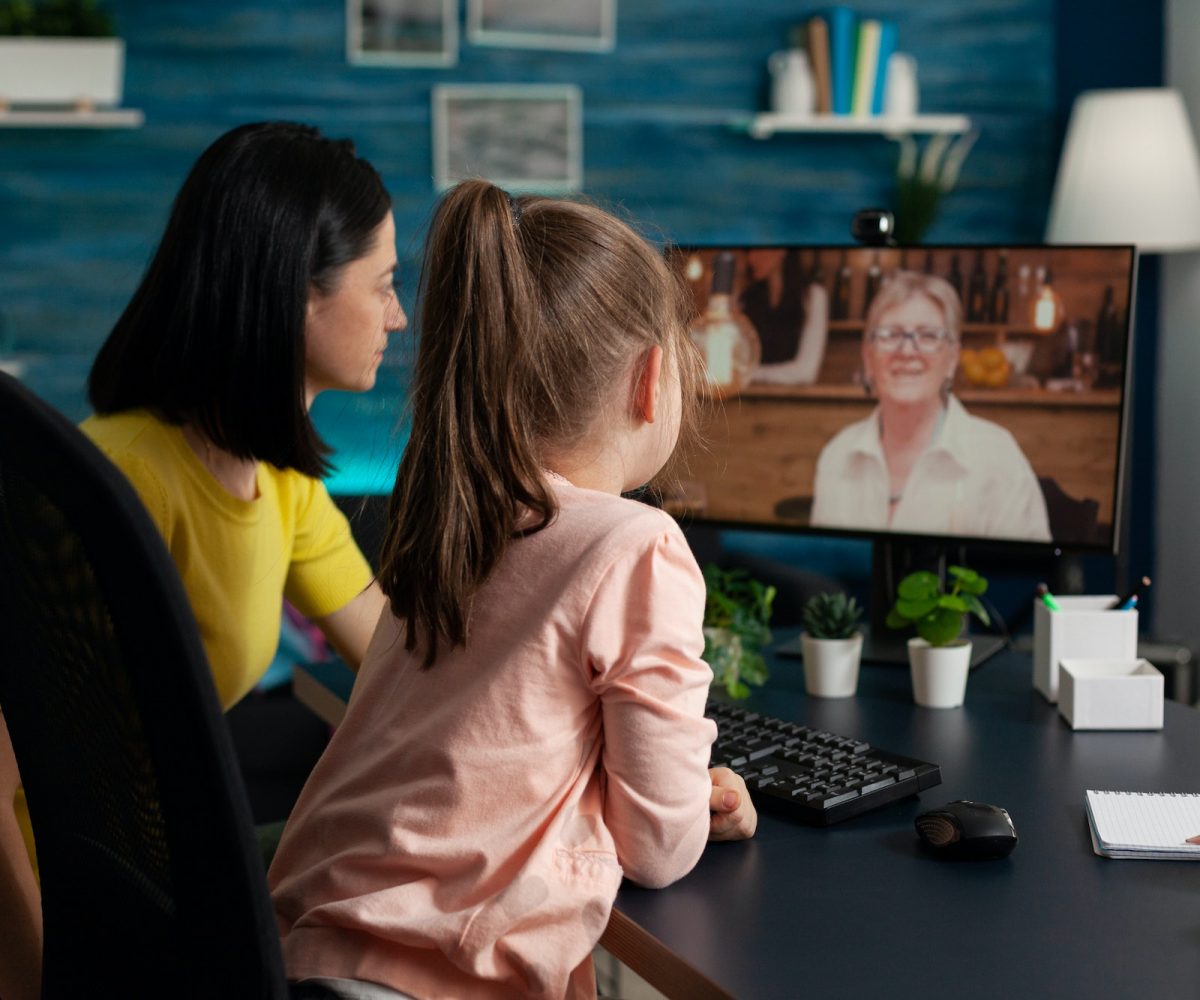 Granddaughter sitting beside parent talking with retired grandmother d