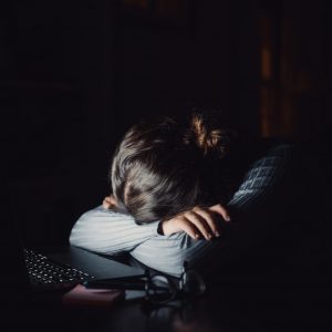 One sad and tired young woman feeling bad covering her face sleeping or resting